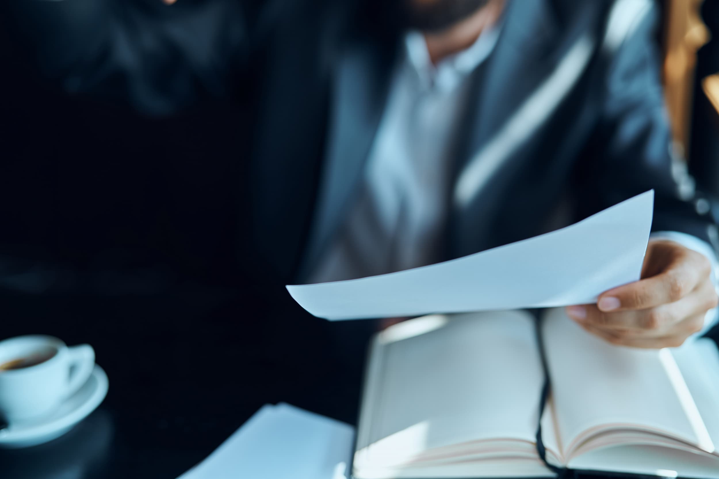 Businessman reviewing Shareholders Agreement and notes in a cafe with coffee